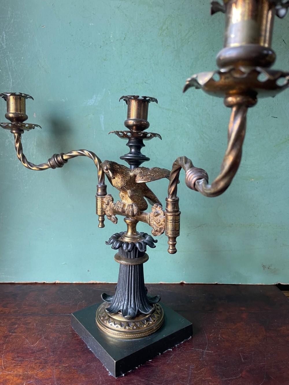 An early nineteenth-century Regency period three-light candelabra featuring adjustable swivelling arms, a central eagle figure perched above a fluted bronze column, and a square plinth base. View IX