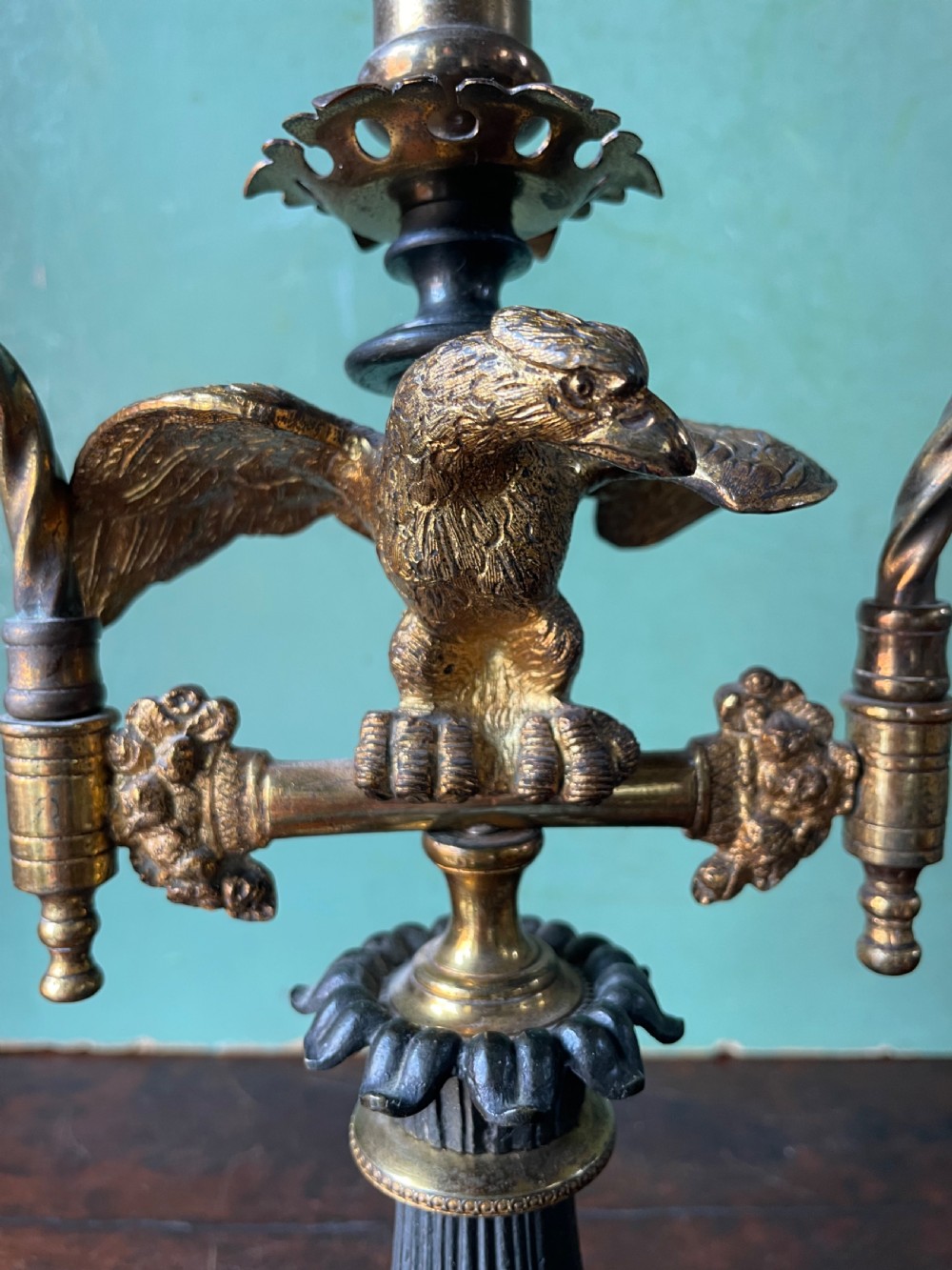 An early nineteenth-century Regency period three-light candelabra featuring adjustable swivelling arms, a central eagle figure perched above a fluted bronze column, and a square plinth base. View XIV