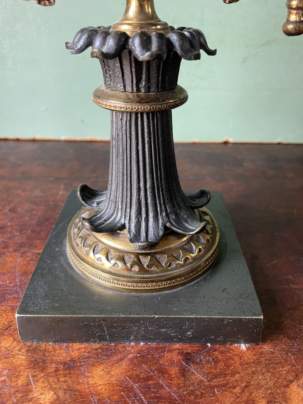 An early nineteenth-century Regency period three-light candelabra featuring adjustable swivelling arms, a central eagle figure perched above a fluted bronze column, and a square plinth base. View XV