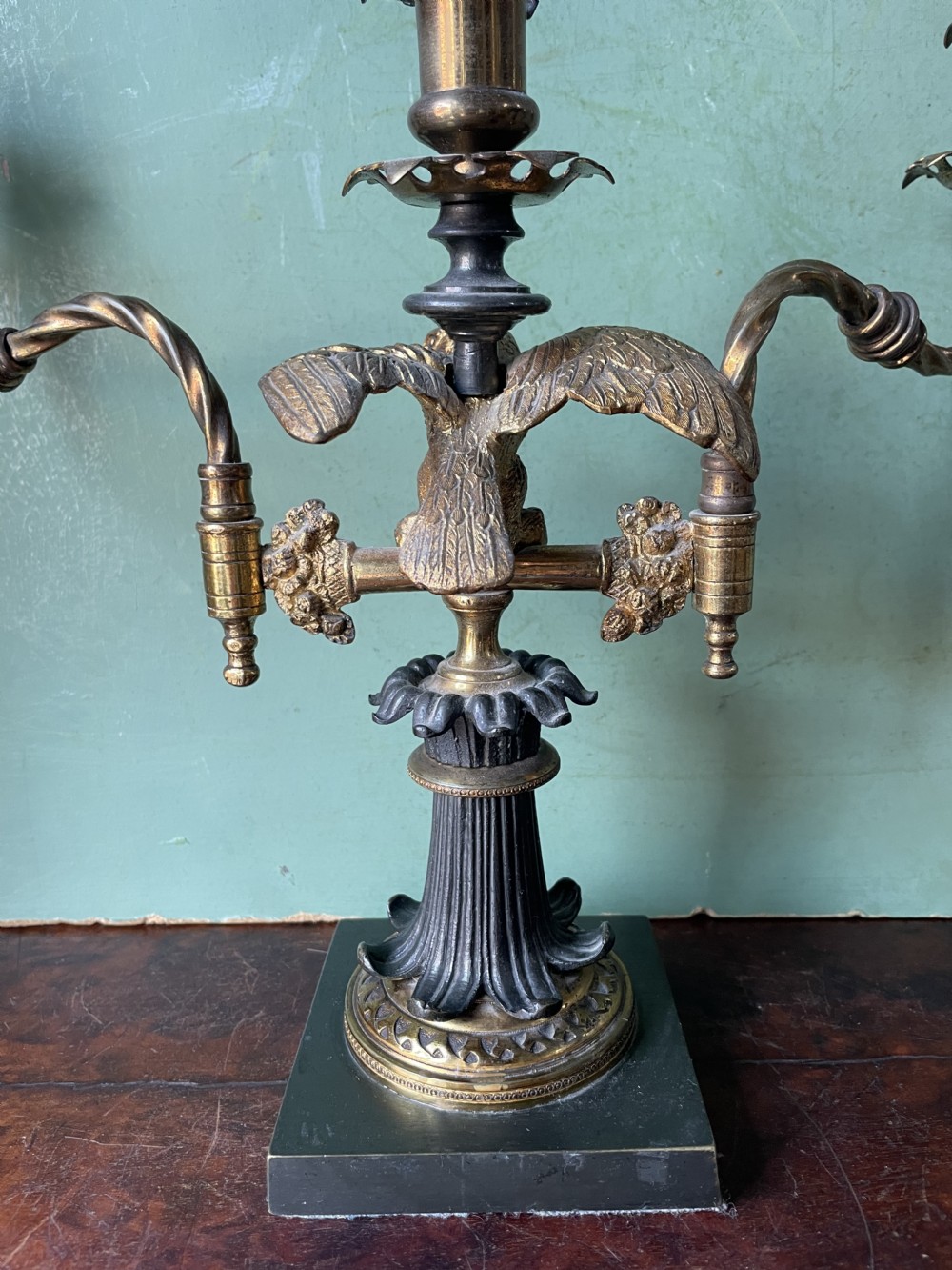 An early nineteenth-century Regency period three-light candelabra featuring adjustable swivelling arms, a central eagle figure perched above a fluted bronze column, and a square plinth base. View XVII