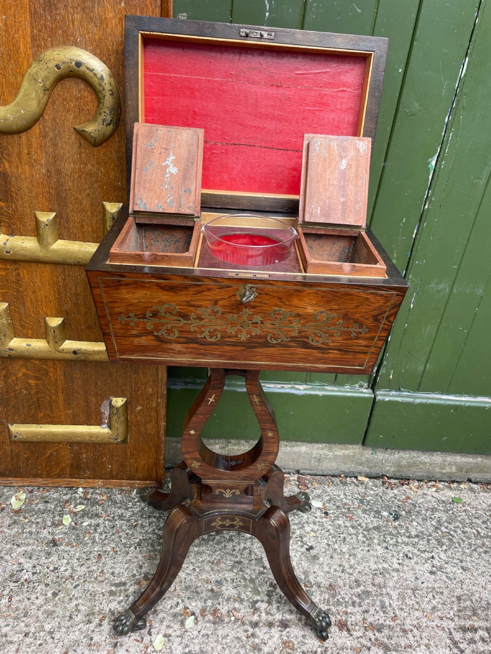 An early 19th-century Regency rosewood teapoy featuring floral brass inlay, a lyre-shaped stem support, and quadruped splayed legs with brass claw feet. View VIII