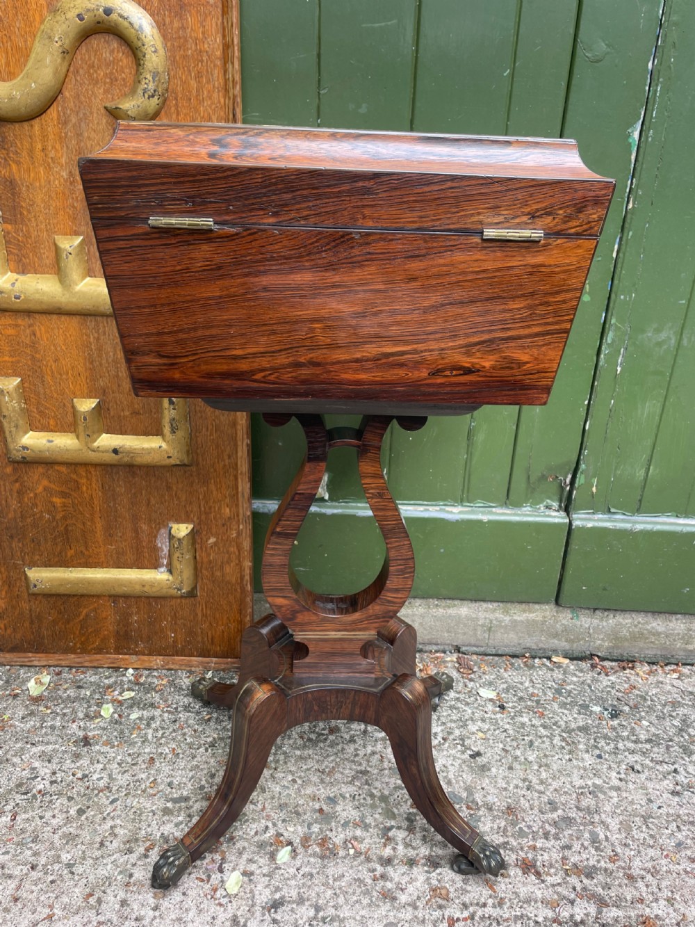 An early 19th-century Regency rosewood teapoy featuring floral brass inlay, a lyre-shaped stem support, and quadruped splayed legs with brass claw feet. View XII