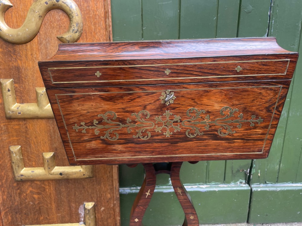An early 19th-century Regency rosewood teapoy featuring floral brass inlay, a lyre-shaped stem support, and quadruped splayed legs with brass claw feet. View XIII