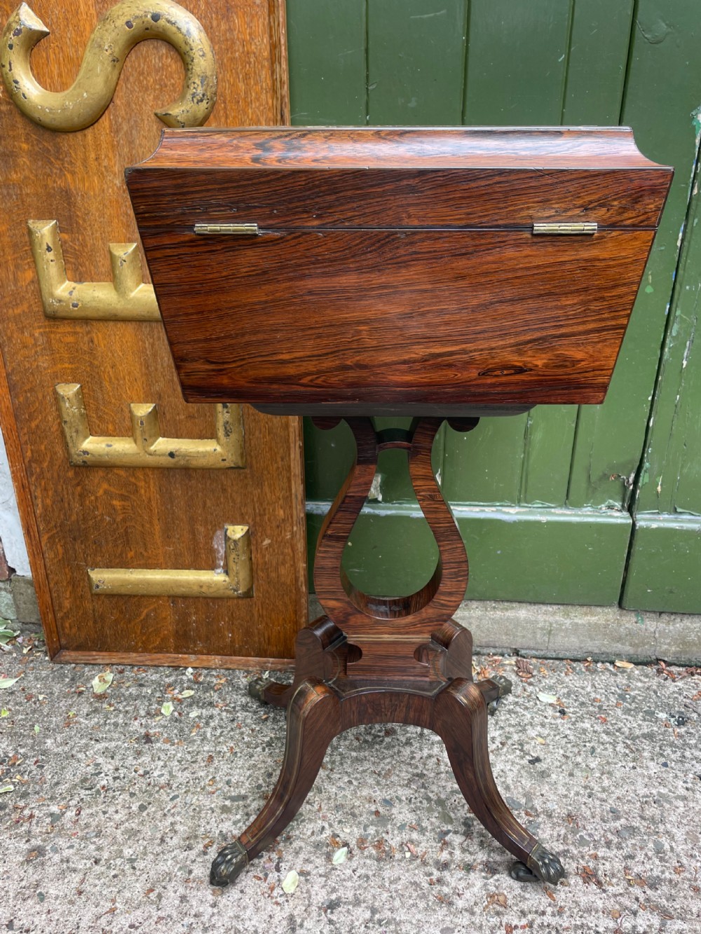 An early 19th-century Regency rosewood teapoy featuring floral brass inlay, a lyre-shaped stem support, and quadruped splayed legs with brass claw feet. View XIV
