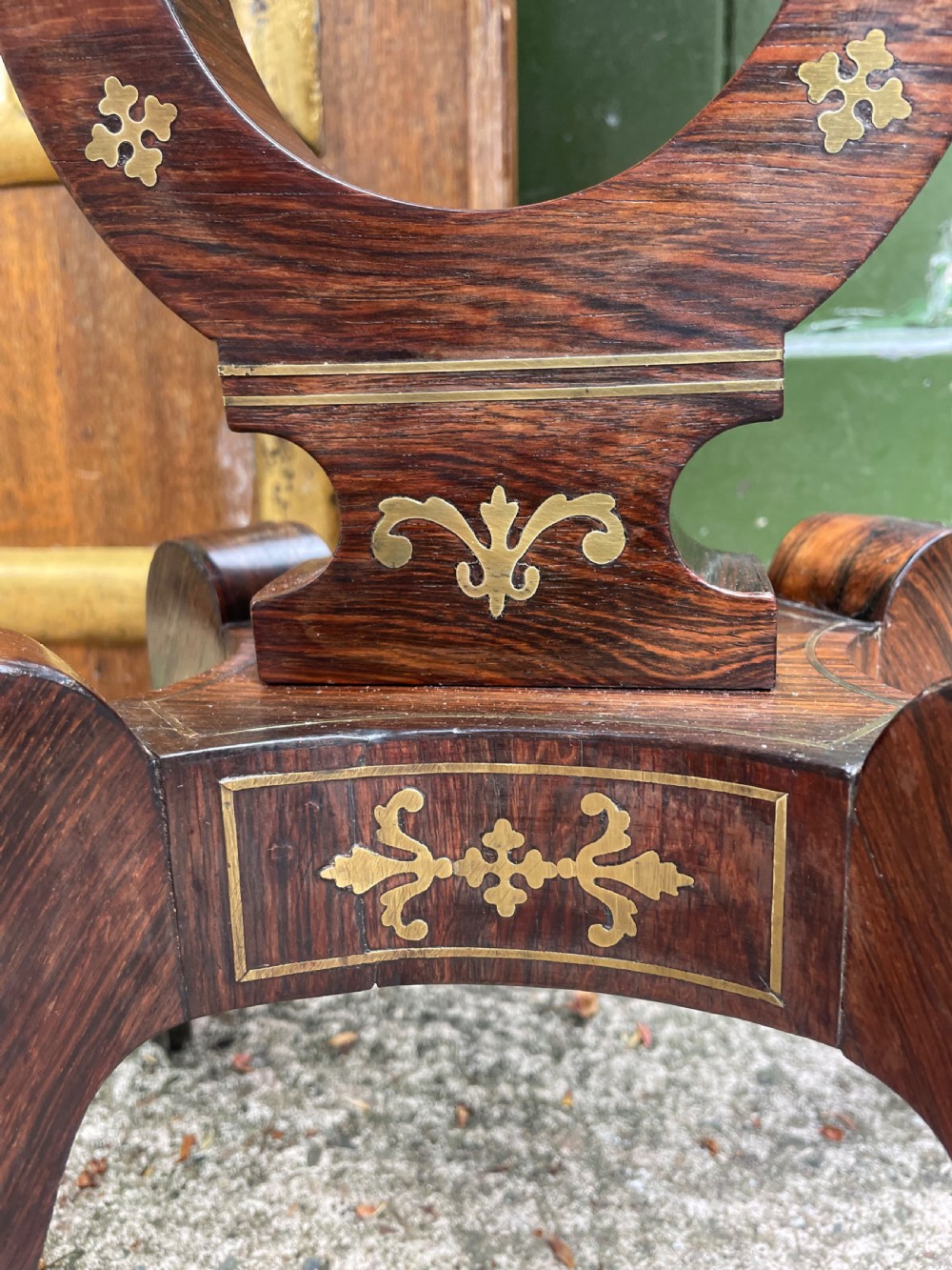 An early 19th-century Regency rosewood teapoy featuring floral brass inlay, a lyre-shaped stem support, and quadruped splayed legs with brass claw feet. View XVIII
