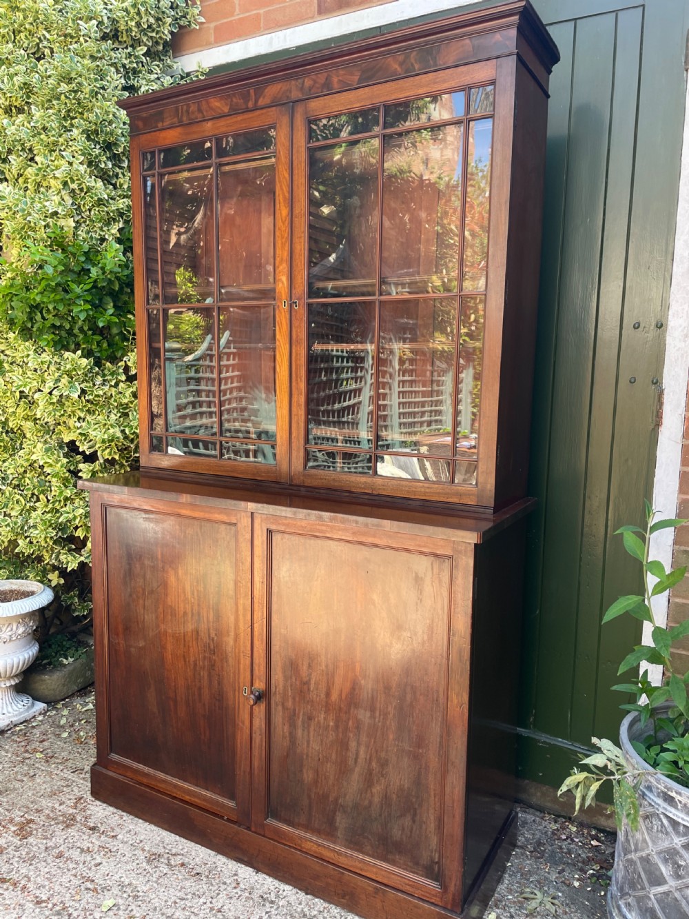 An early nineteenth-century mahogany library bookcase featuring astragal-glazed upper doors and double panelled lower doors. View II