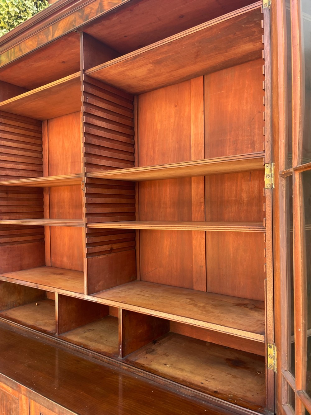 An early nineteenth-century mahogany library bookcase featuring astragal-glazed upper doors and double panelled lower doors. View III