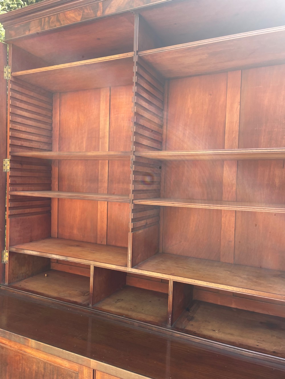 An early nineteenth-century mahogany library bookcase featuring astragal-glazed upper doors and double panelled lower doors. View V