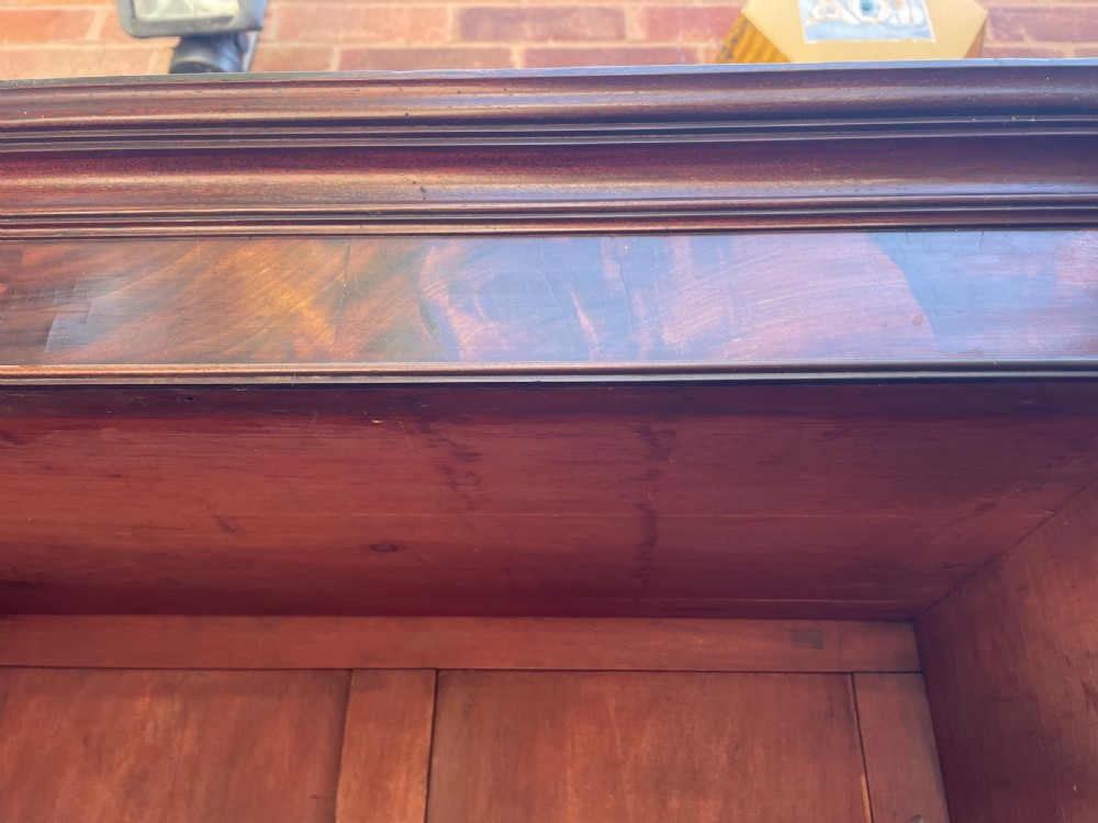 An early nineteenth-century mahogany library bookcase featuring astragal-glazed upper doors and double panelled lower doors. View VI