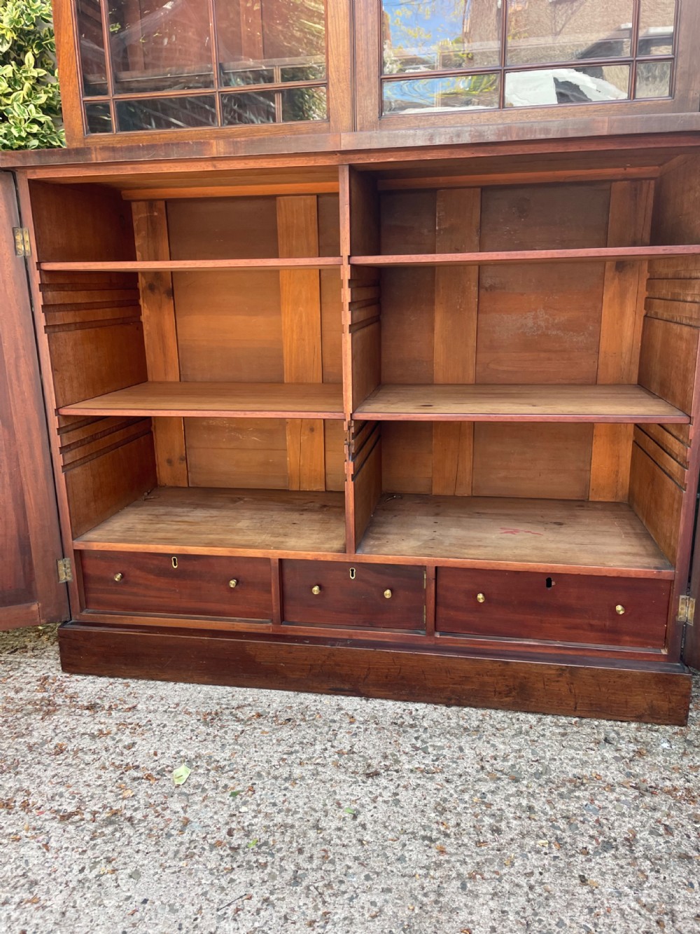An early nineteenth-century mahogany library bookcase featuring astragal-glazed upper doors and double panelled lower doors. View IX