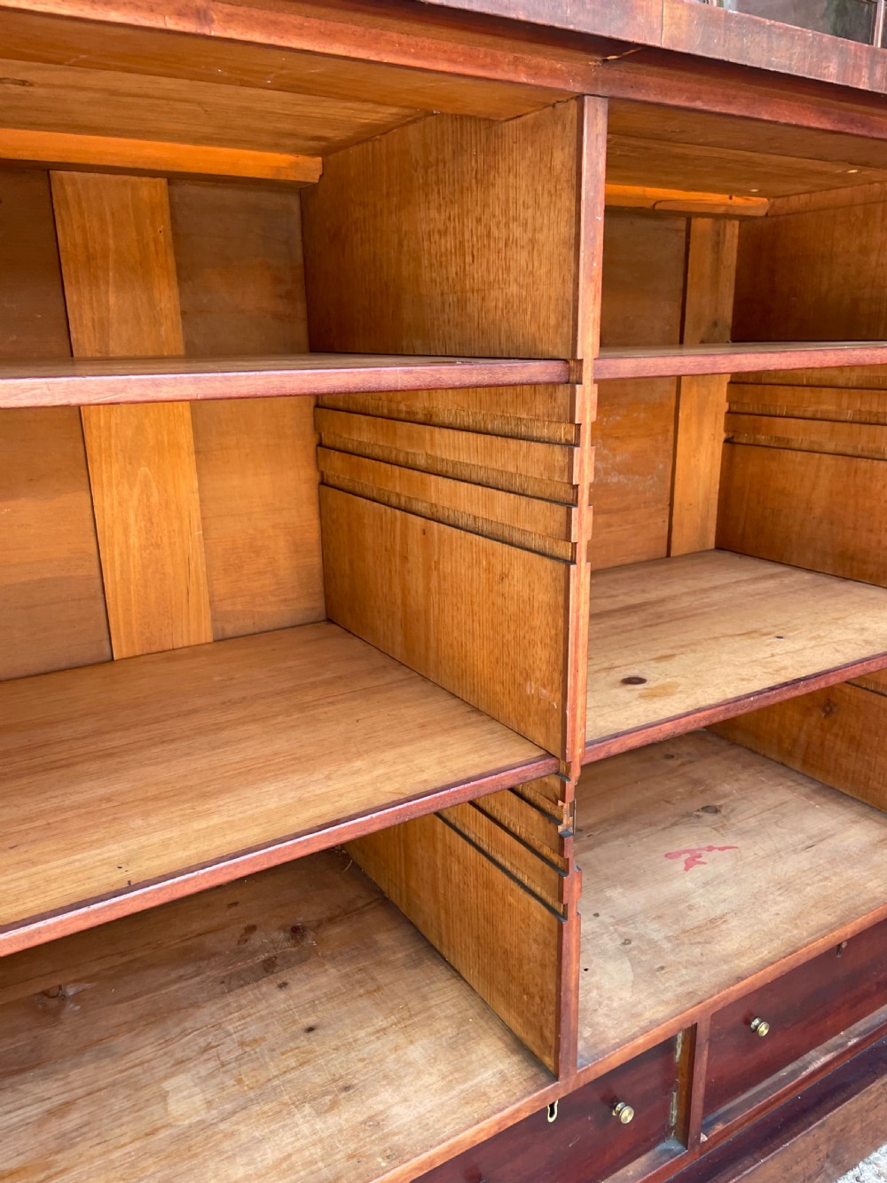 An early nineteenth-century mahogany library bookcase featuring astragal-glazed upper doors and double panelled lower doors. View XI