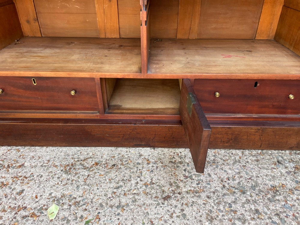 An early nineteenth-century mahogany library bookcase featuring astragal-glazed upper doors and double panelled lower doors. View XV