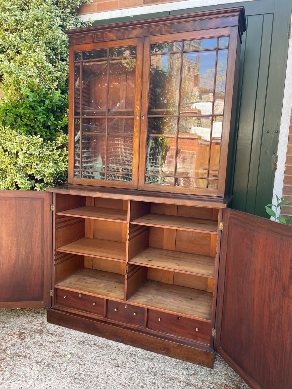 An early nineteenth-century mahogany library bookcase featuring astragal-glazed upper doors and double panelled lower doors. View XVI
