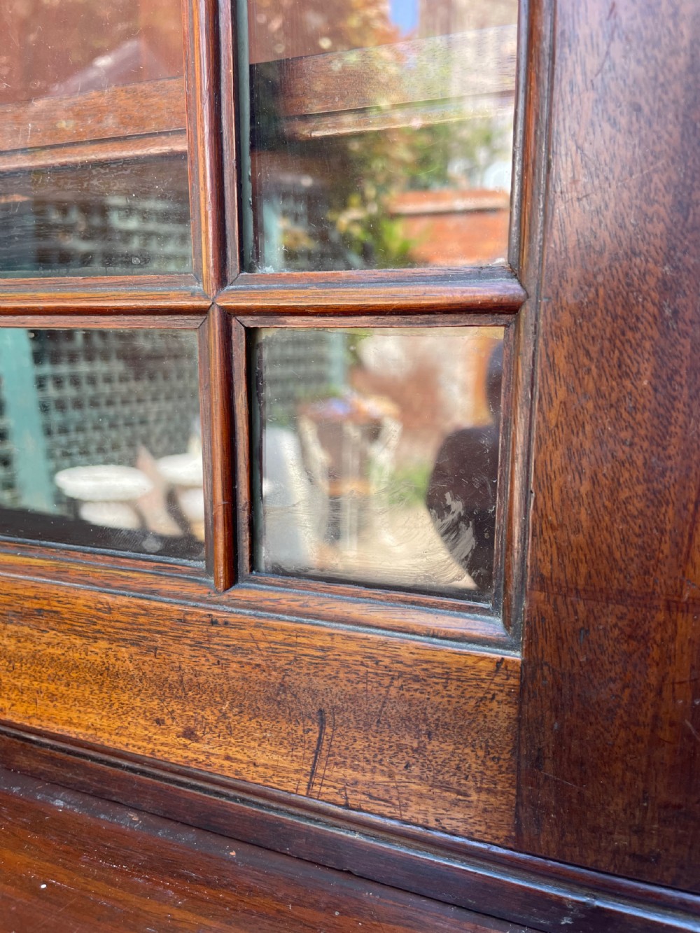 An early nineteenth-century mahogany library bookcase featuring astragal-glazed upper doors and double panelled lower doors. View XIX