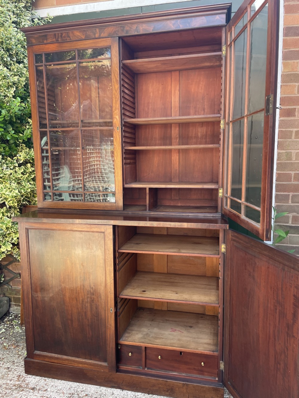 An early nineteenth-century mahogany library bookcase featuring astragal-glazed upper doors and double panelled lower doors. View VIII