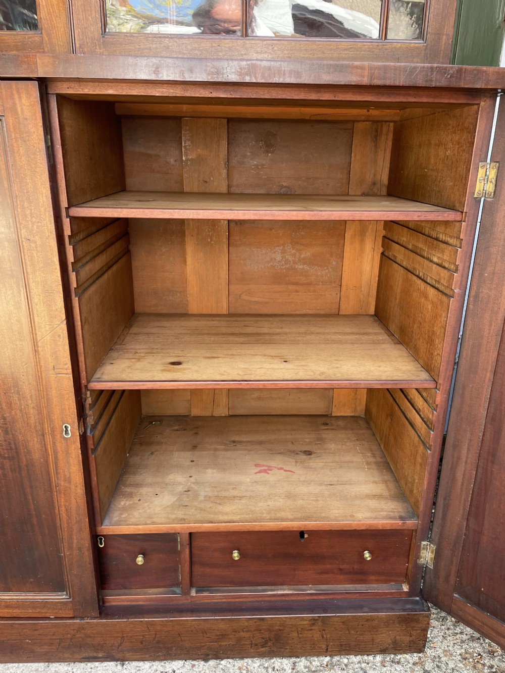 An early nineteenth-century mahogany library bookcase featuring astragal-glazed upper doors and double panelled lower doors. View XXIV