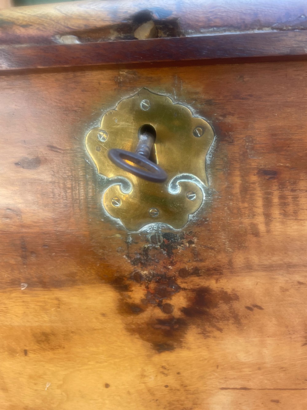 A mid-eighteenth century solid cedar trunk featuring decorative brass corner brackets, brass straps, and a central brass keyhole escutcheon. View III