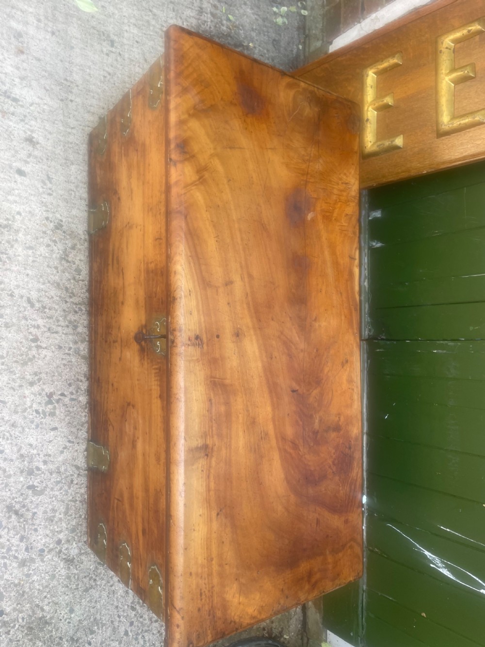 A mid-eighteenth century solid cedar trunk featuring decorative brass corner brackets, brass straps, and a central brass keyhole escutcheon. View V