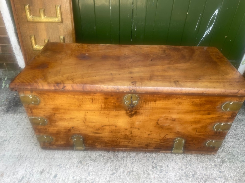 A mid-eighteenth century solid cedar trunk featuring decorative brass corner brackets, brass straps, and a central brass keyhole escutcheon. View VI