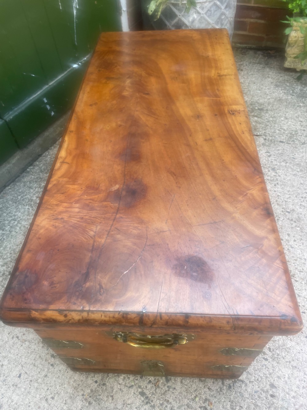 A mid-eighteenth century solid cedar trunk featuring decorative brass corner brackets, brass straps, and a central brass keyhole escutcheon. View VIII