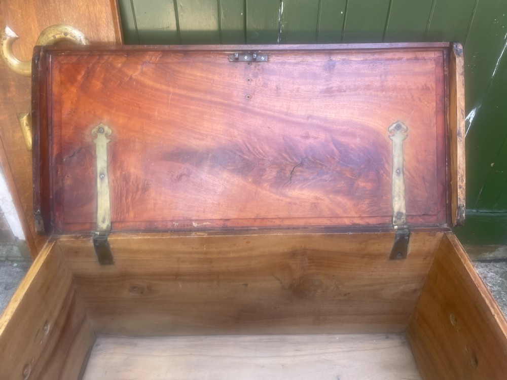 A mid-eighteenth century solid cedar trunk featuring decorative brass corner brackets, brass straps, and a central brass keyhole escutcheon. View X