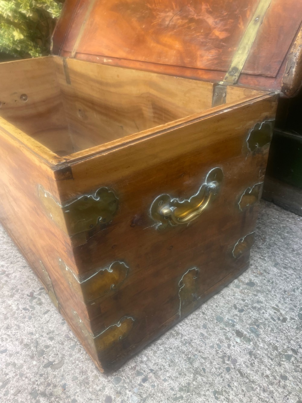 A mid-eighteenth century solid cedar trunk featuring decorative brass corner brackets, brass straps, and a central brass keyhole escutcheon. View XI