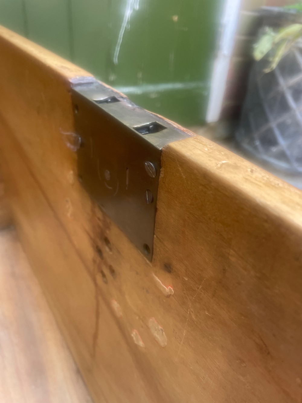 A mid-eighteenth century solid cedar trunk featuring decorative brass corner brackets, brass straps, and a central brass keyhole escutcheon. View XV