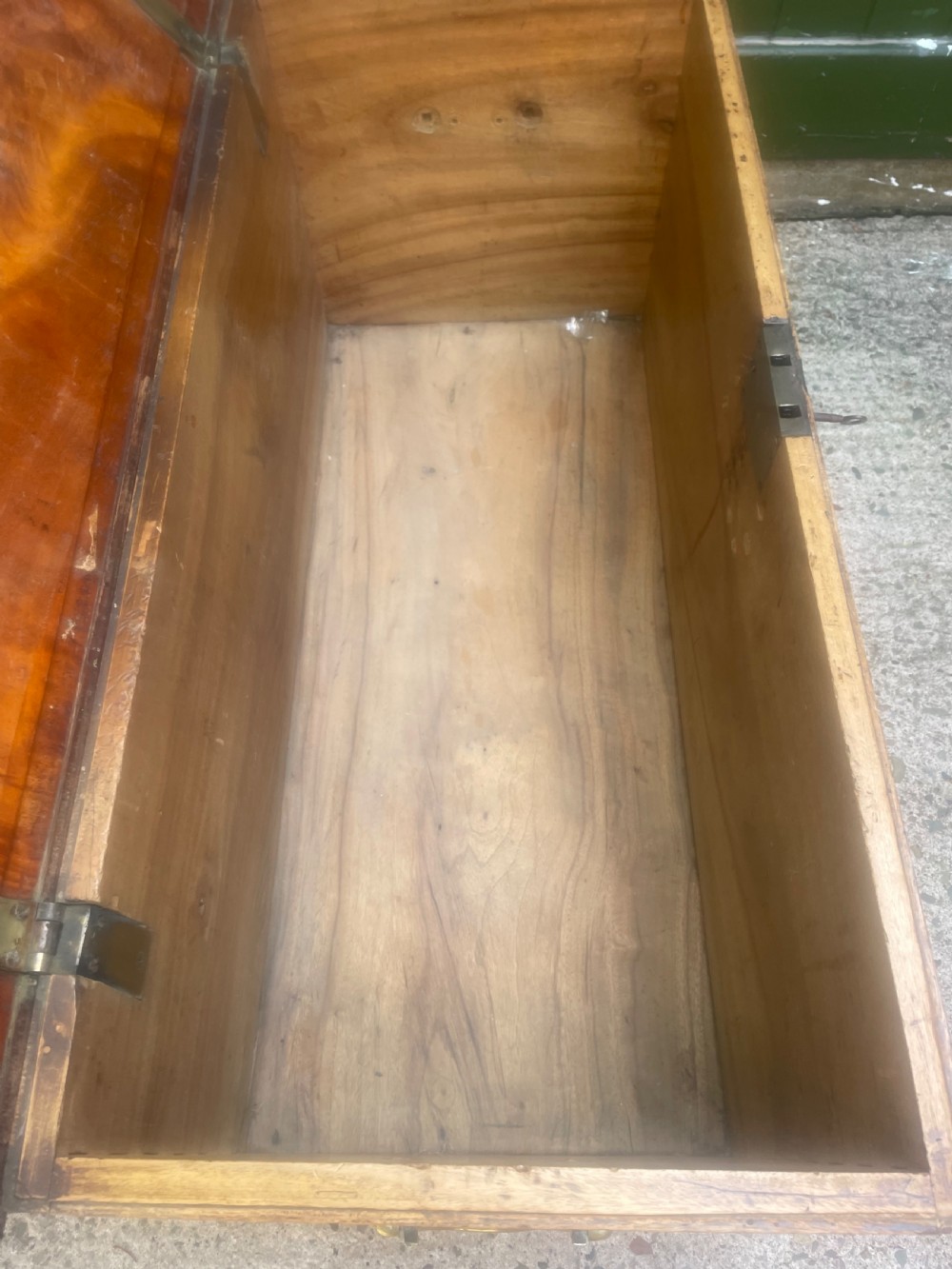 A mid-eighteenth century solid cedar trunk featuring decorative brass corner brackets, brass straps, and a central brass keyhole escutcheon. View XVI