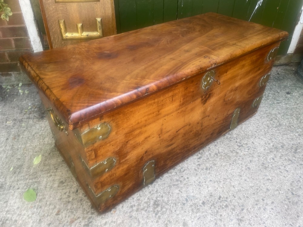 A mid-eighteenth century solid cedar trunk featuring decorative brass corner brackets, brass straps, and a central brass keyhole escutcheon. View XVIII