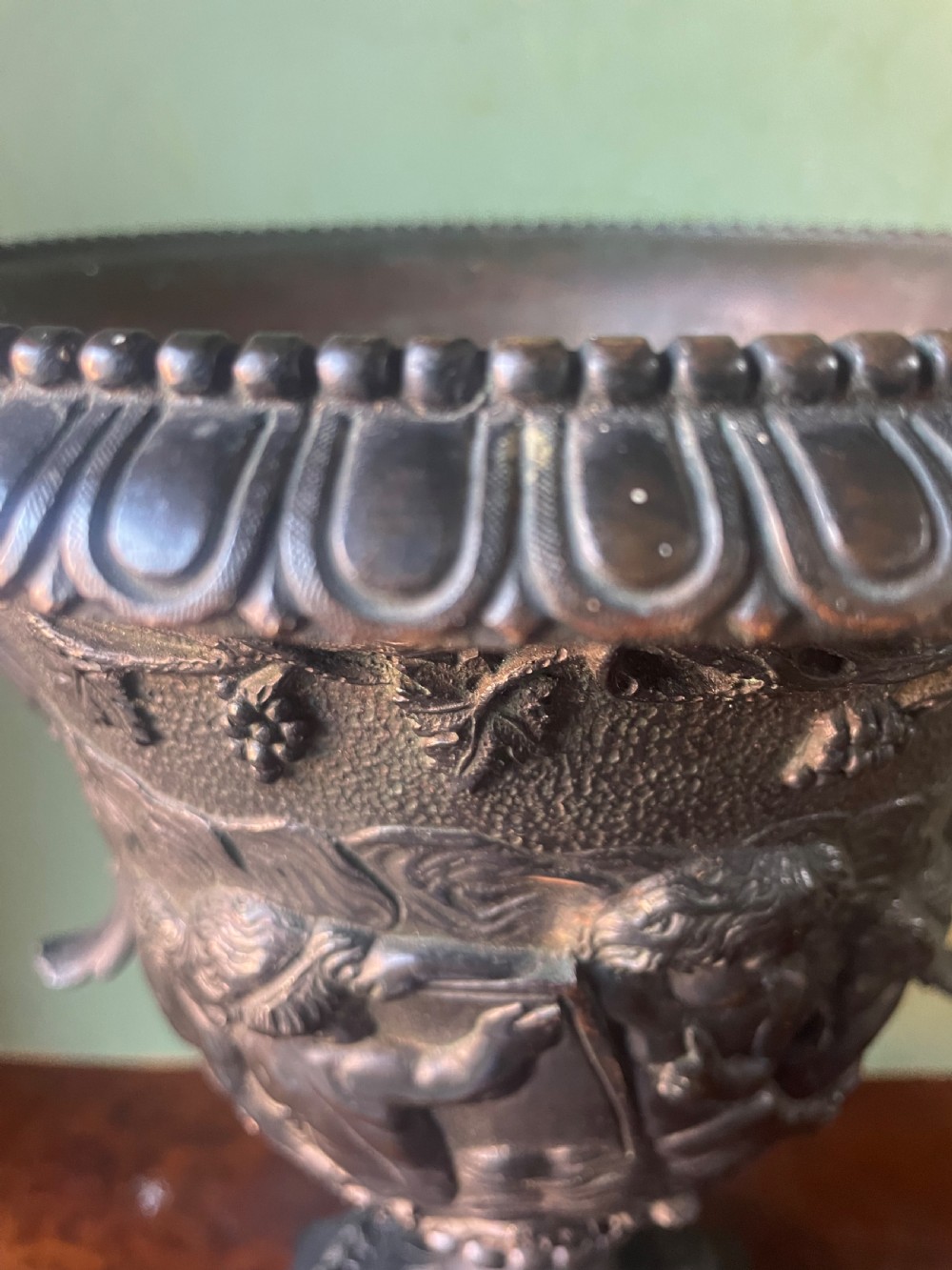 A 19th-century French dark bronze campana-shaped urn featuring relief carving of putti, satyr mask handles, and a square pedestal base. View II