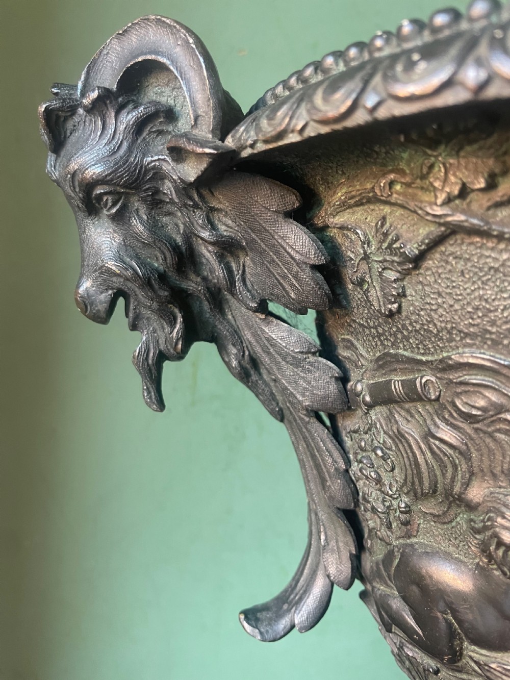 A 19th-century French dark bronze campana-shaped urn featuring relief carving of putti, satyr mask handles, and a square pedestal base. View III