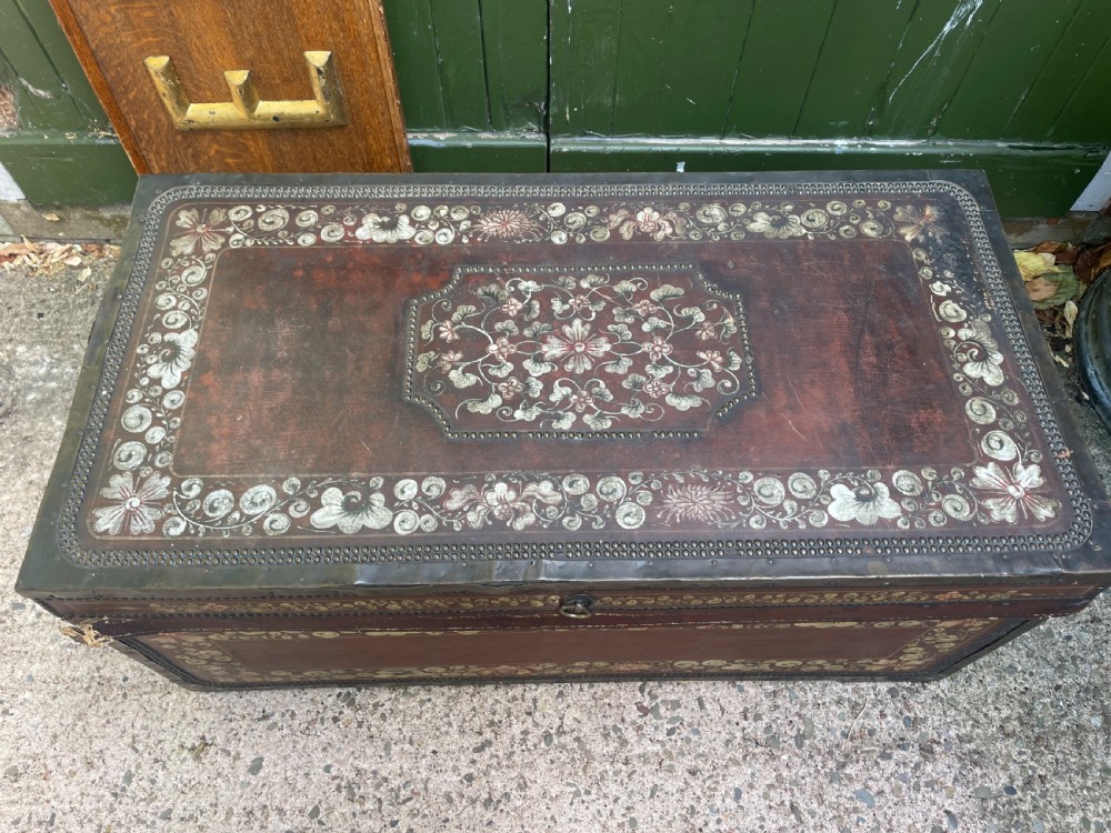 A 19th-century Chinese export leather trunk decorated with hand-painted gold and red floral motifs and brass stud borders. View V