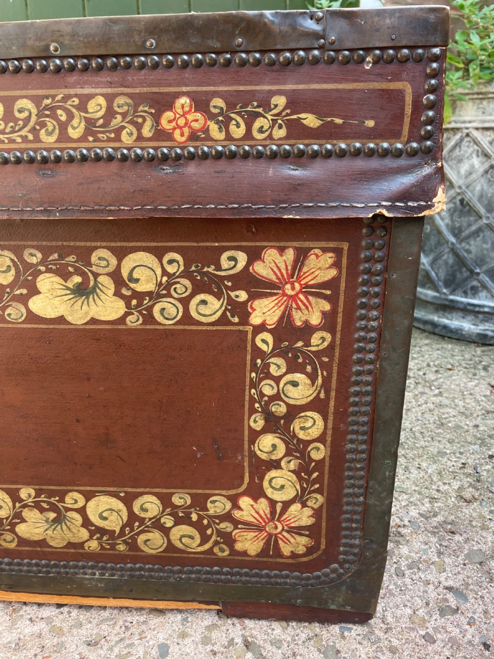 A 19th-century Chinese export leather trunk decorated with hand-painted gold and red floral motifs and brass stud borders. View X
