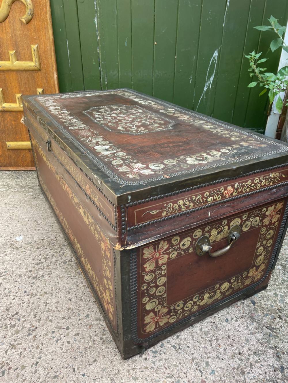 A 19th-century Chinese export leather trunk decorated with hand-painted gold and red floral motifs and brass stud borders. View XVI