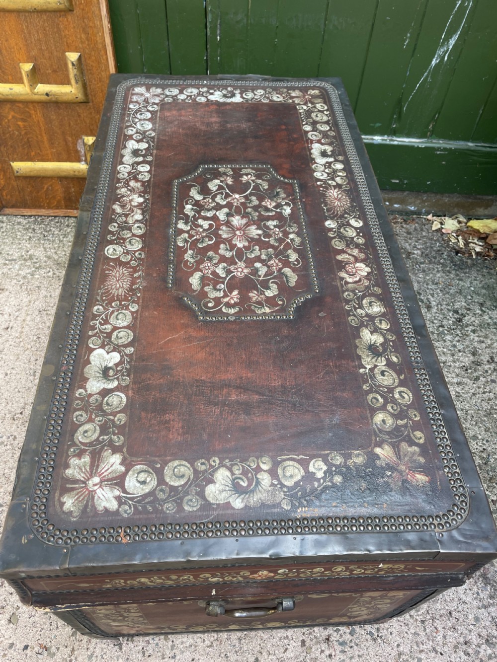 A 19th-century Chinese export leather trunk decorated with hand-painted gold and red floral motifs and brass stud borders. View XVII