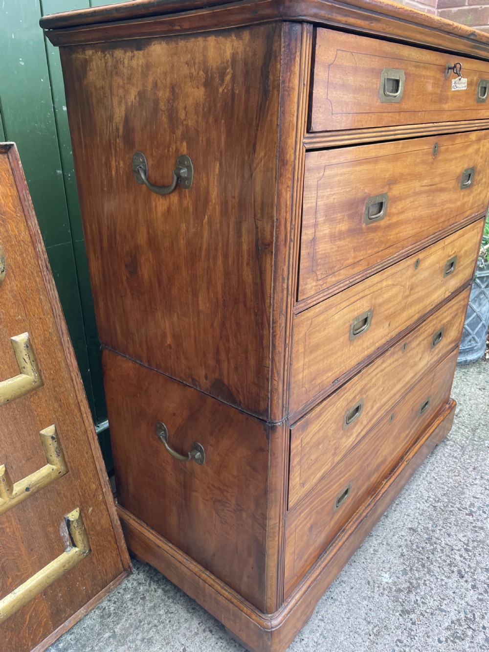 A nineteenth-century two-section camphorwood military campaign chest of drawers with flush brass handles and keyhole escutcheons. View V