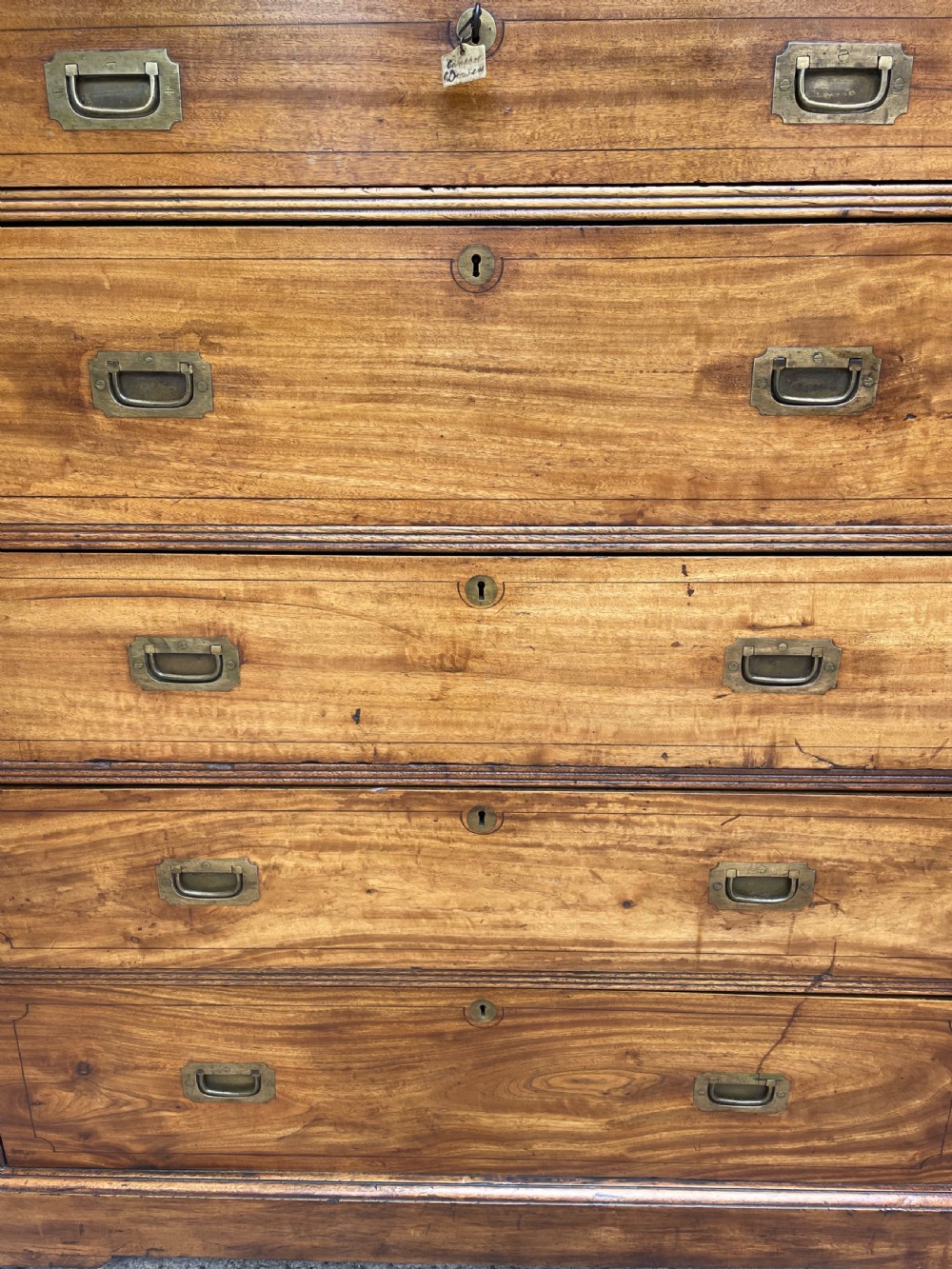 A nineteenth-century two-section camphorwood military campaign chest of drawers with flush brass handles and keyhole escutcheons. View X