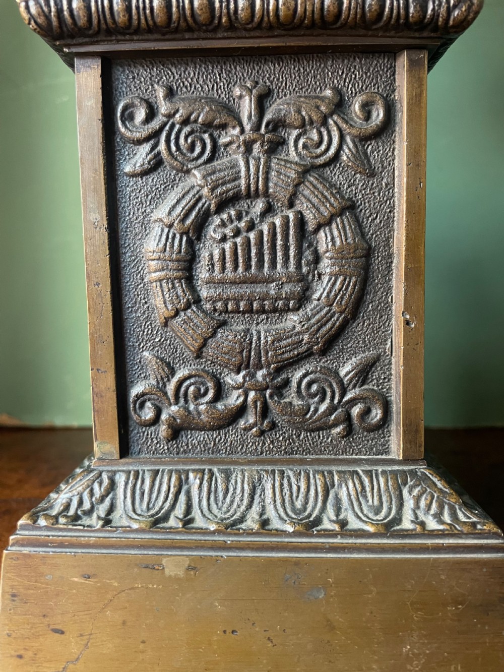 A pair of early 19th-century French Charles X bronze campana-shaped urns with fluted bodies and classical relief motifs on square plinth bases. View VII