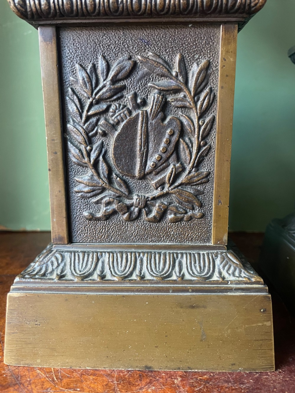 A pair of early 19th-century French Charles X bronze campana-shaped urns with fluted bodies and classical relief motifs on square plinth bases. View VIII
