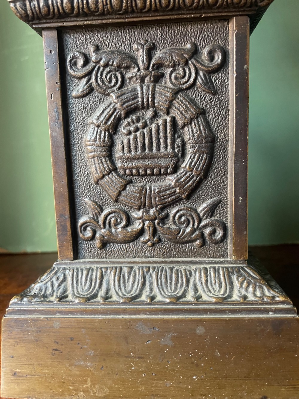 A pair of early 19th-century French Charles X bronze campana-shaped urns with fluted bodies and classical relief motifs on square plinth bases. View IX