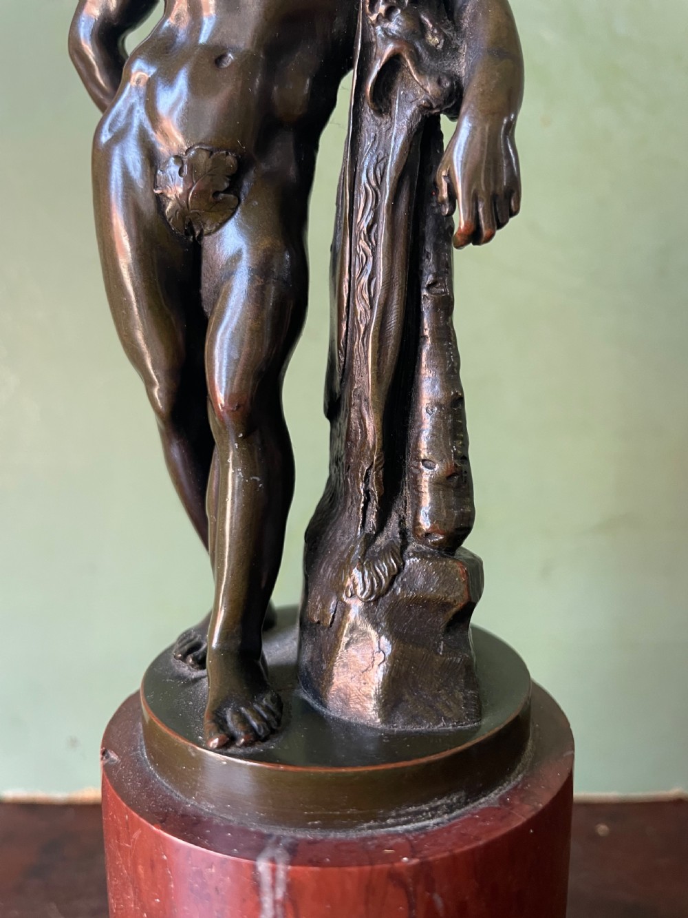 A patinated bronze study of the Farnese Hercules standing against a club draped in lion skin, mounted on a red marble plinth and black base. View XII