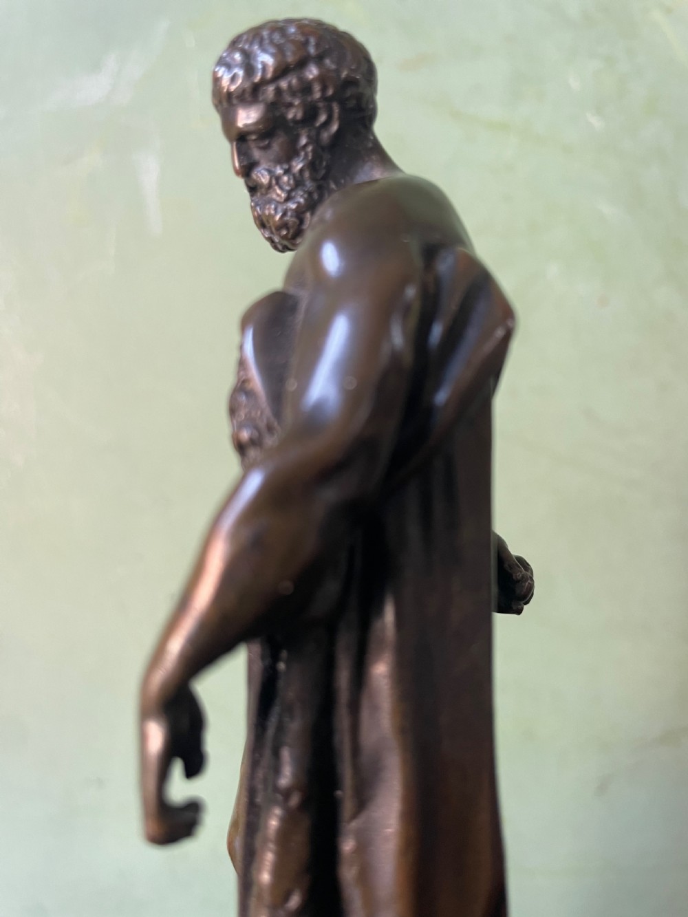 A patinated bronze study of the Farnese Hercules standing against a club draped in lion skin, mounted on a red marble plinth and black base. View XV