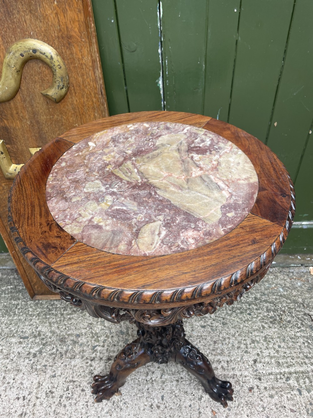 A late nineteenth-century Chinese dark hardwood occasional table featuring a round inset marble top, intricately carved dragon column, and a tripod base. View III