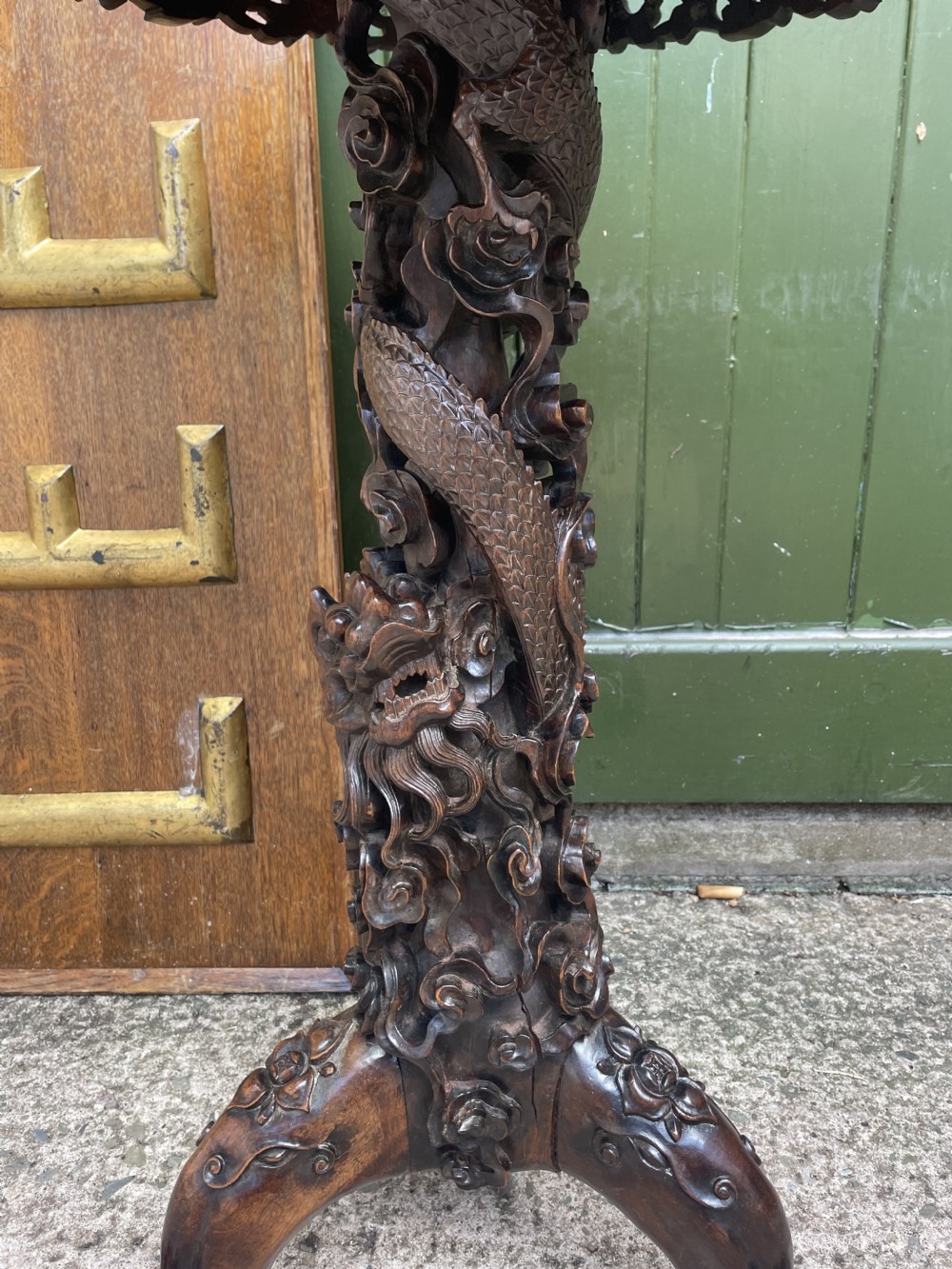 A late nineteenth-century Chinese dark hardwood occasional table featuring a round inset marble top, intricately carved dragon column, and a tripod base. View IV