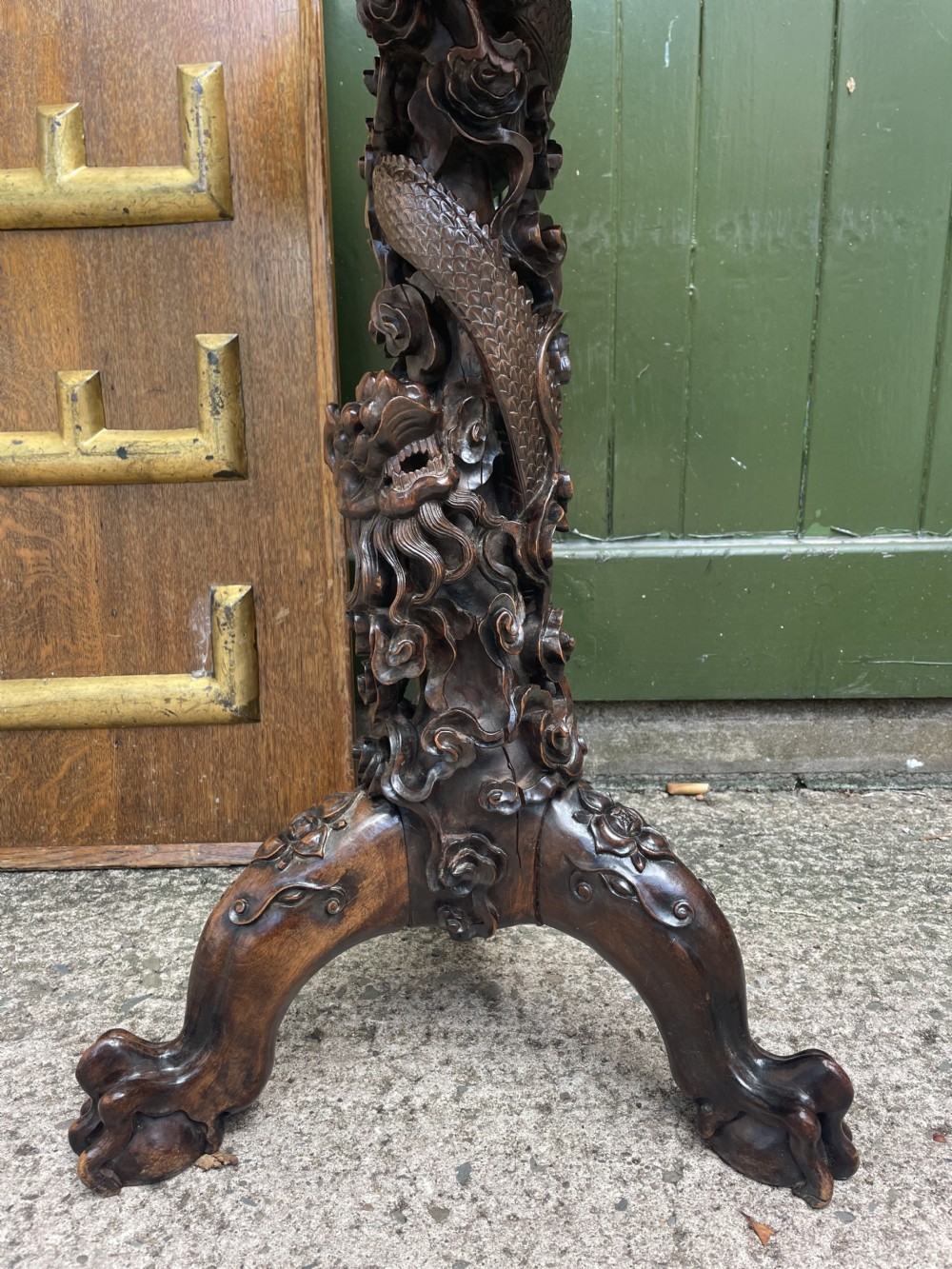 A late nineteenth-century Chinese dark hardwood occasional table featuring a round inset marble top, intricately carved dragon column, and a tripod base. View V