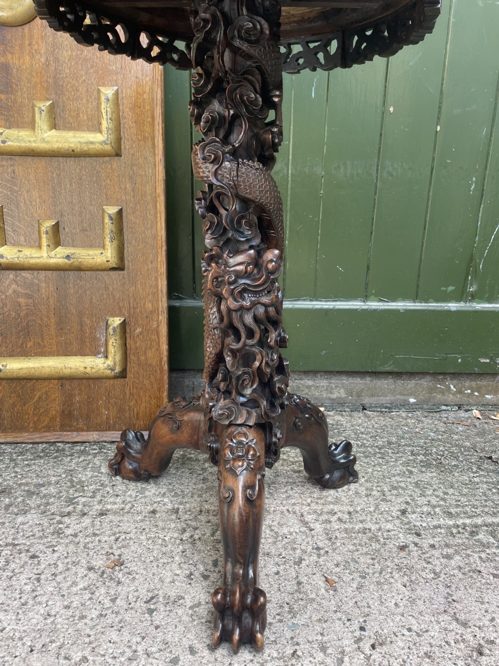 A late nineteenth-century Chinese dark hardwood occasional table featuring a round inset marble top, intricately carved dragon column, and a tripod base. View VI