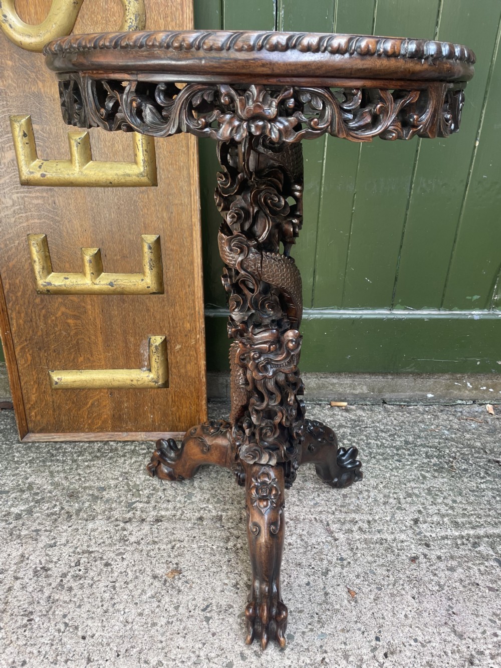 A late nineteenth-century Chinese dark hardwood occasional table featuring a round inset marble top, intricately carved dragon column, and a tripod base. View XV