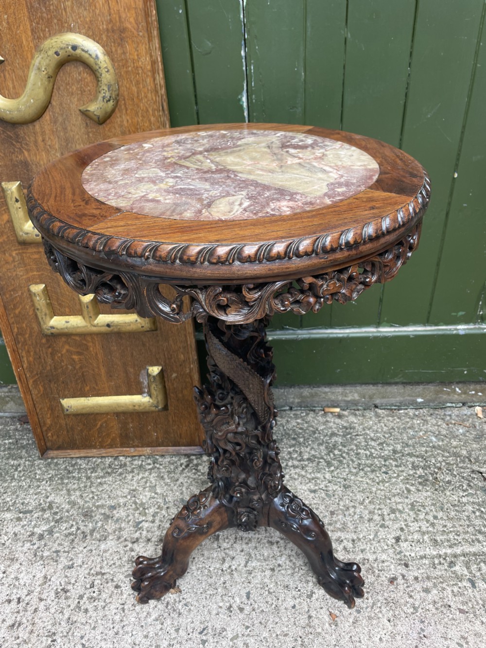 A late nineteenth-century Chinese dark hardwood occasional table featuring a round inset marble top, intricately carved dragon column, and a tripod base. View XIV
