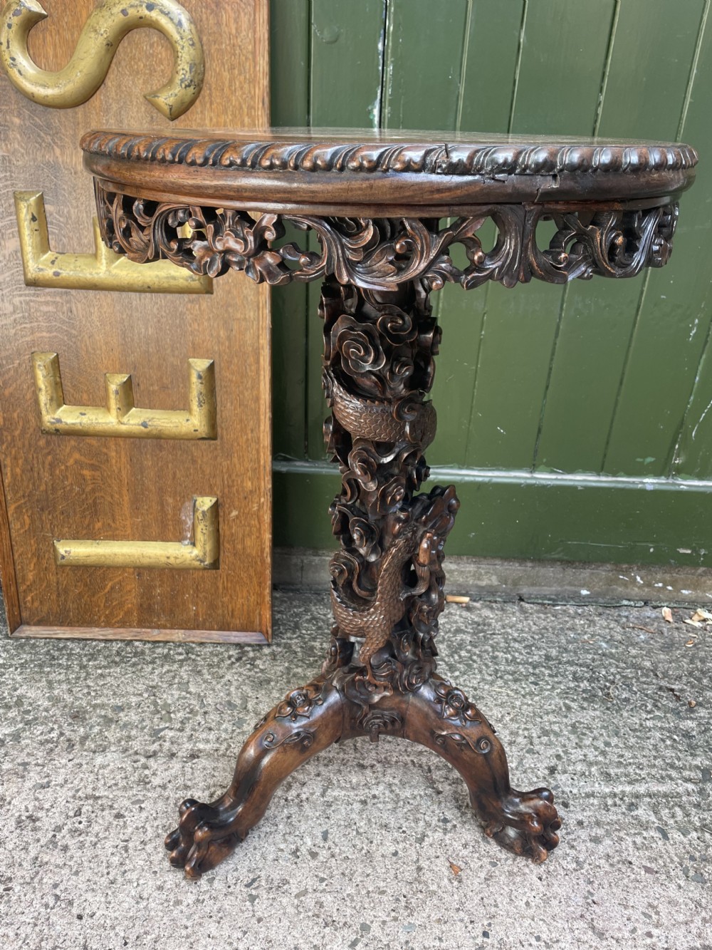 A late nineteenth-century Chinese dark hardwood occasional table featuring a round inset marble top, intricately carved dragon column, and a tripod base. View XIX