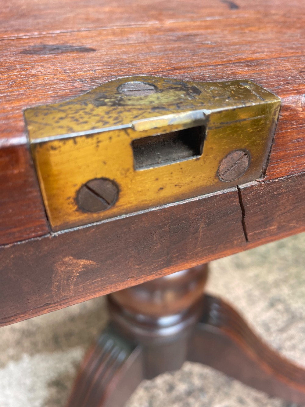 A late George III period circular mahogany tilt-top table shown in a vertical position, featuring a single-piece top and reeded tripod legs with brass castors. View XI